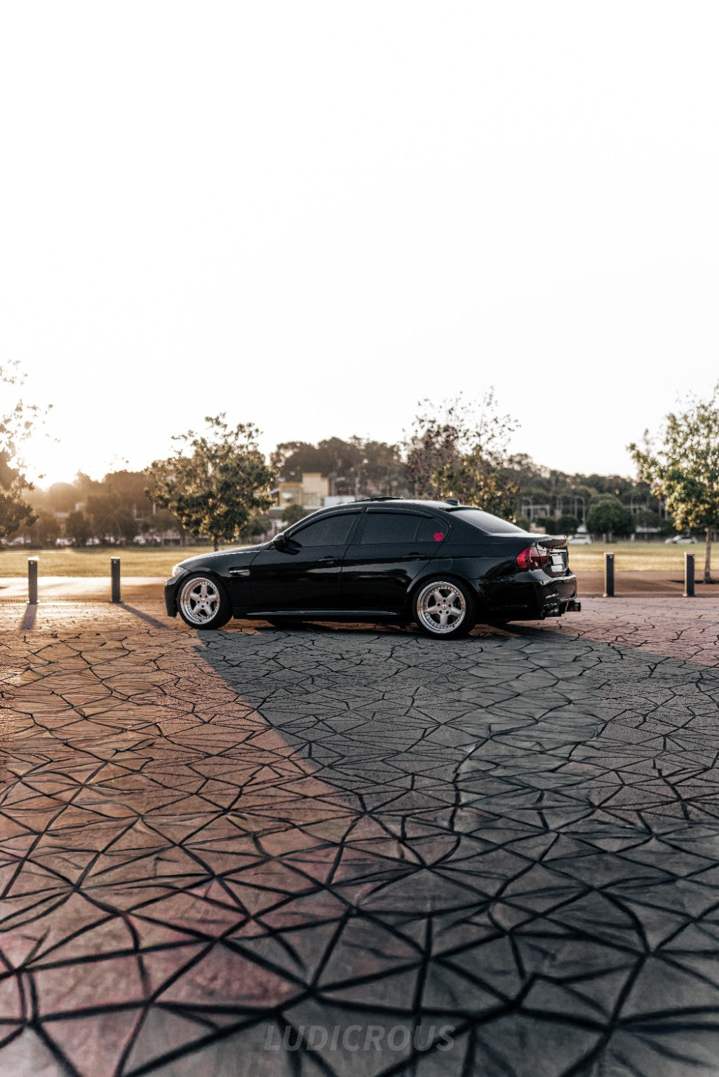 Side profile of the black E9X AutoHaus BMW E90 in warm sunset light