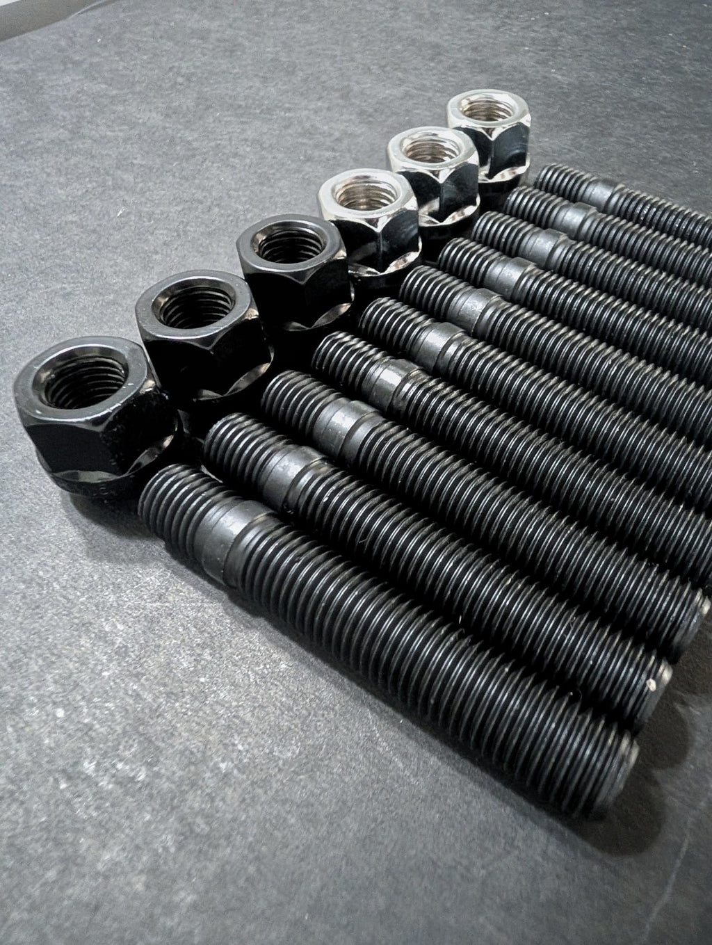 Close-up of E9X AutoHaus black wheel studs with black and chrome wheel nuts