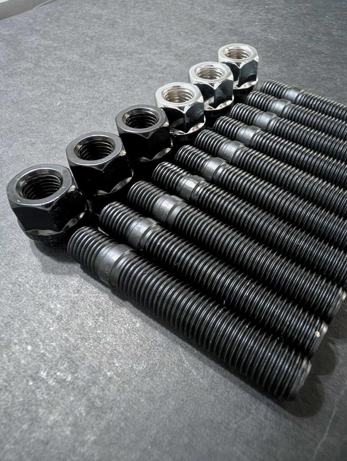 Close-up of E9X AutoHaus black wheel studs with black and chrome wheel nuts