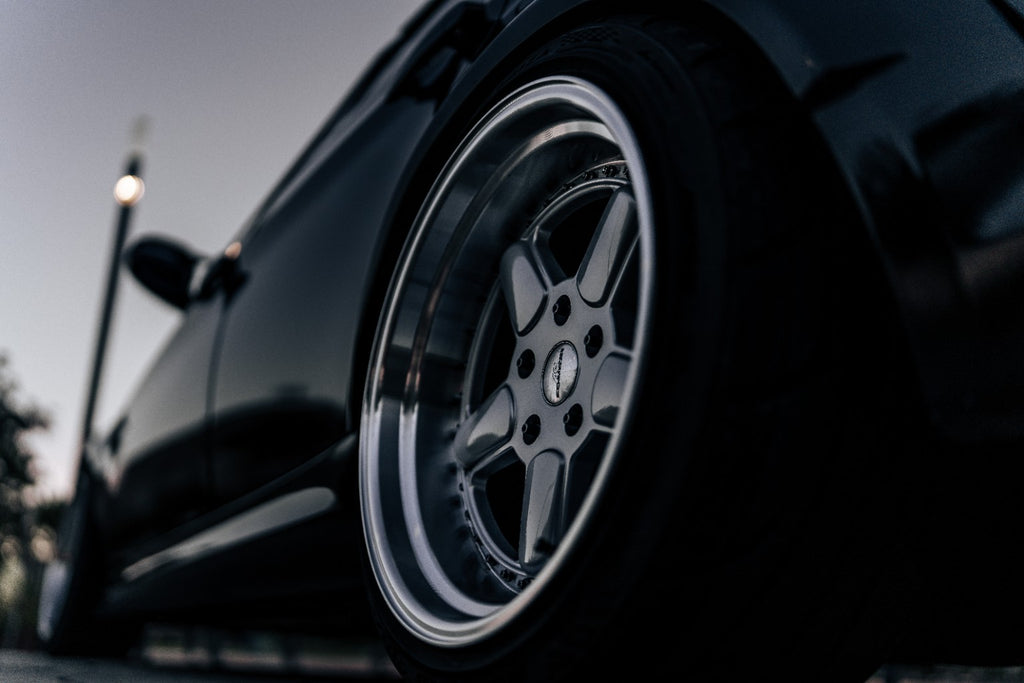 Close-up of wheel hardware fitted to a silver wheel on a black BMW E90