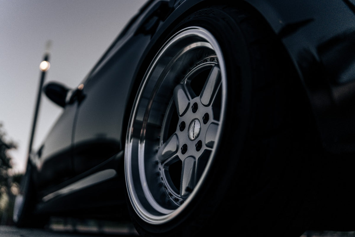 Close-up of wheel hardware fitted to a silver wheel on a black BMW E90