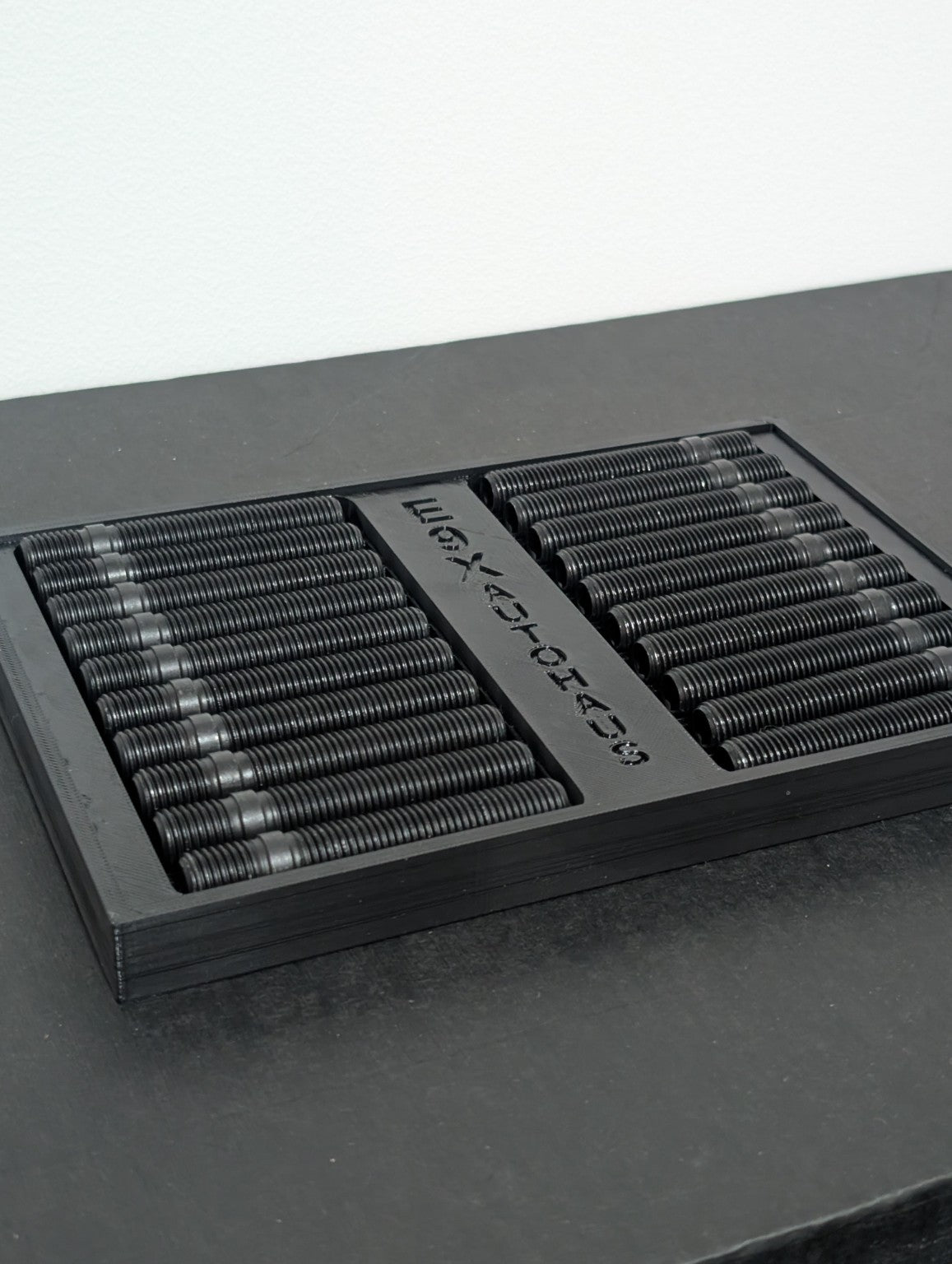 E9X AutoHaus wheel studs arranged in a branded display tray